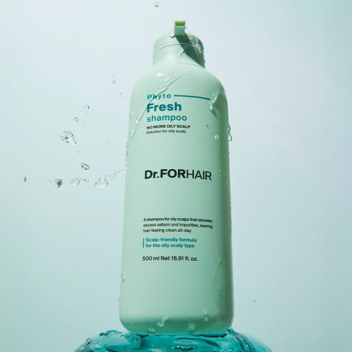 A bottle of Dr. FORHAIR Phyto Fresh Shampoo with a label and branding, placed on a splash of water, emphasizing its freshness and cleaning properties.