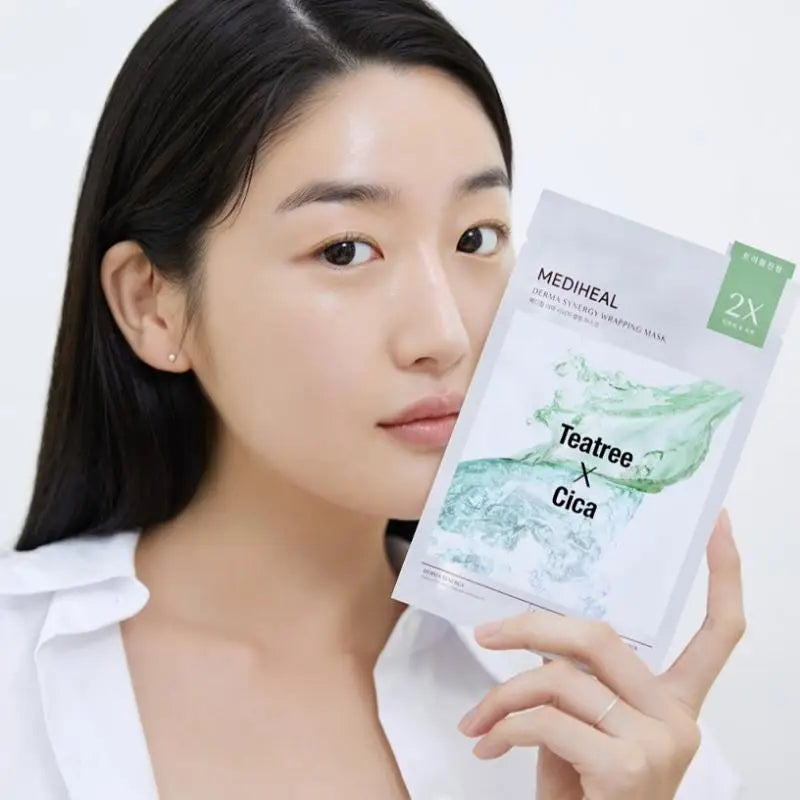 Woman holding a Mediheal Teatree Cica sheet mask against a white background