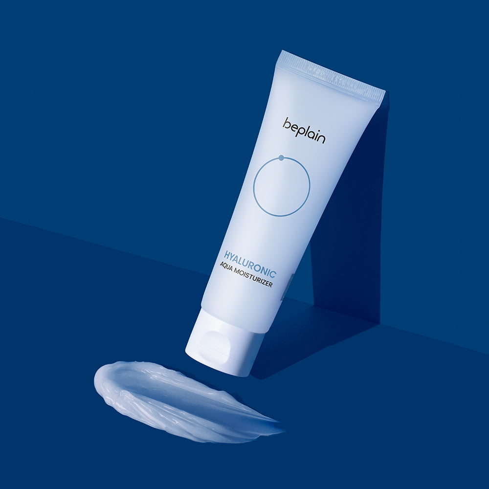 A white tube of beplain Hyaluronic Aqua Moisturizer with a blue cap, placed on a blue background with a small amount of product spilled in front.