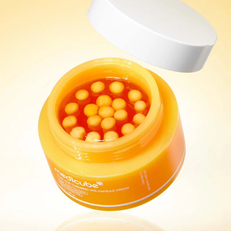 medicube Kojic Acid Turmeric Vita Capsule Cream with visible pearls on a light yellow background
