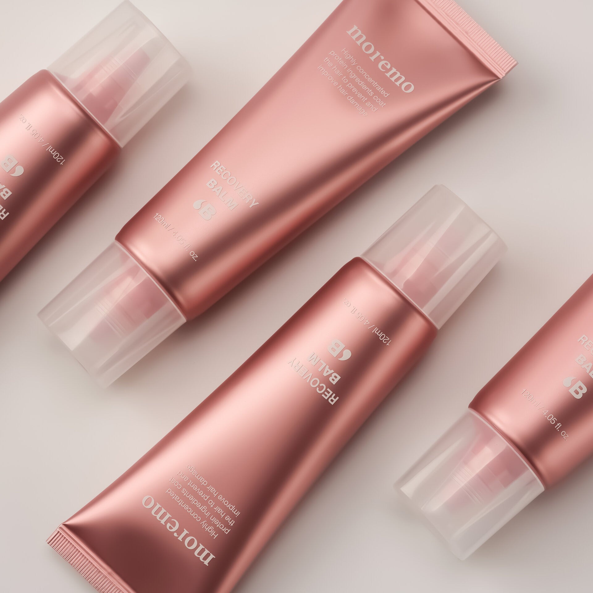 Set of pink skincare products with 'moremo' branding on a light background