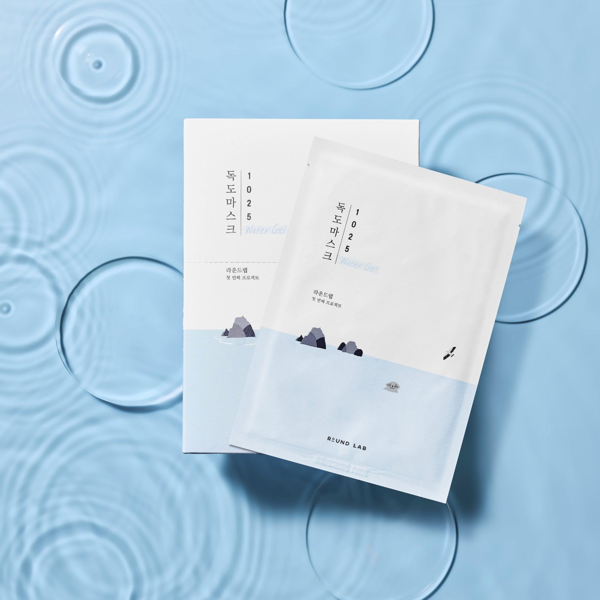 A packaged water gel mask sheet with a blue and white design, labeled in Korean, on a background with water droplets and ripples.